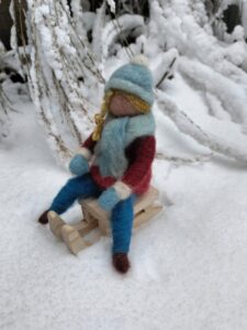 meisje op slee in de sneeuw naaldvilt